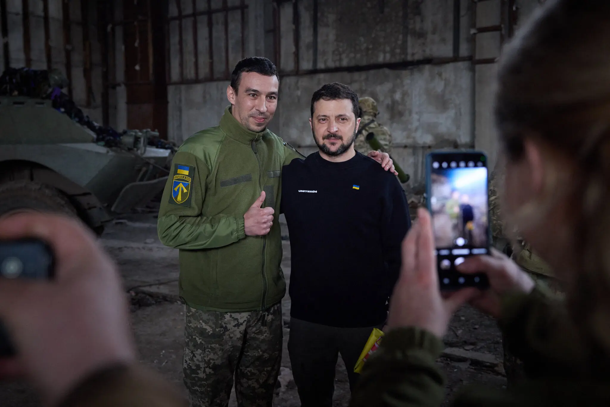 На фото, опублікованому українським урядом, президент Володимир Зеленський зустрічає військових у середу під Бахмутом.